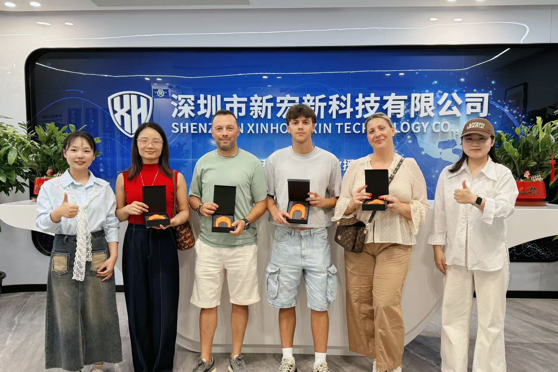 International buyers visiting Shenzhen XinHongXin Technology headquarters with company signage